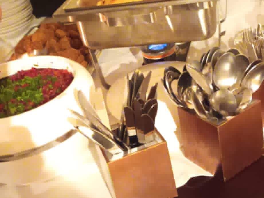 A table with various of Sudanese Dishes, along with cutlery and plates.